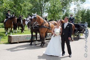 Das Brautpaar vor der Kutsche und den Reitern...